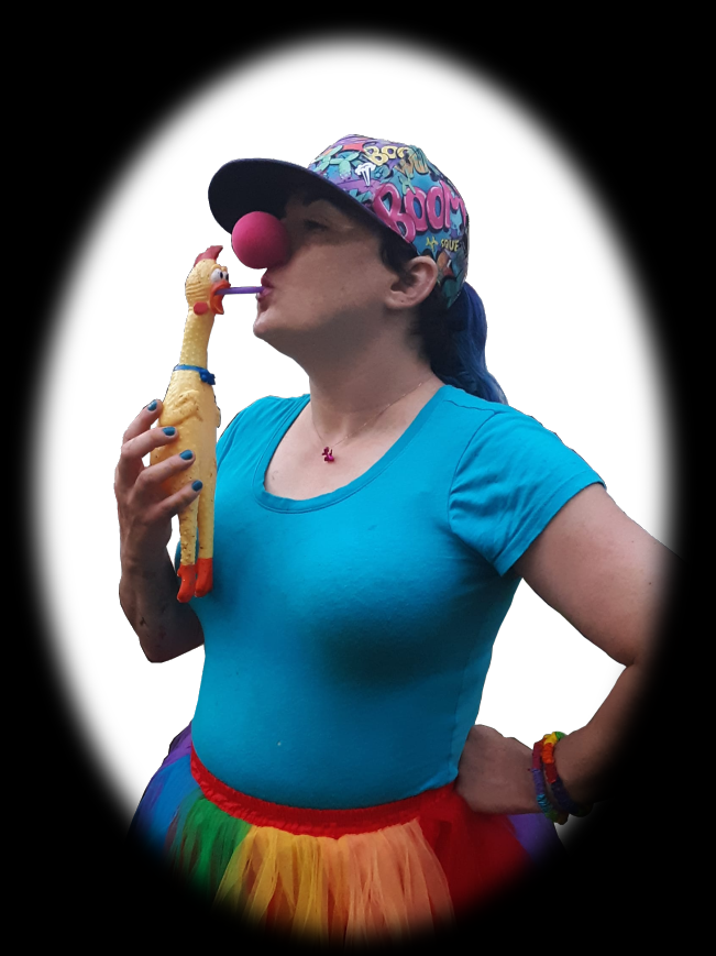 A woman with a blue pony tail, wearing a multicolored baseball hat, fit turquoise t-shirt, and rainbow tutu, drinks from a straw that is sticking out of a rubber chicken.